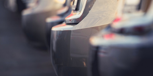 Rear bumpers of cars in a parking lot.