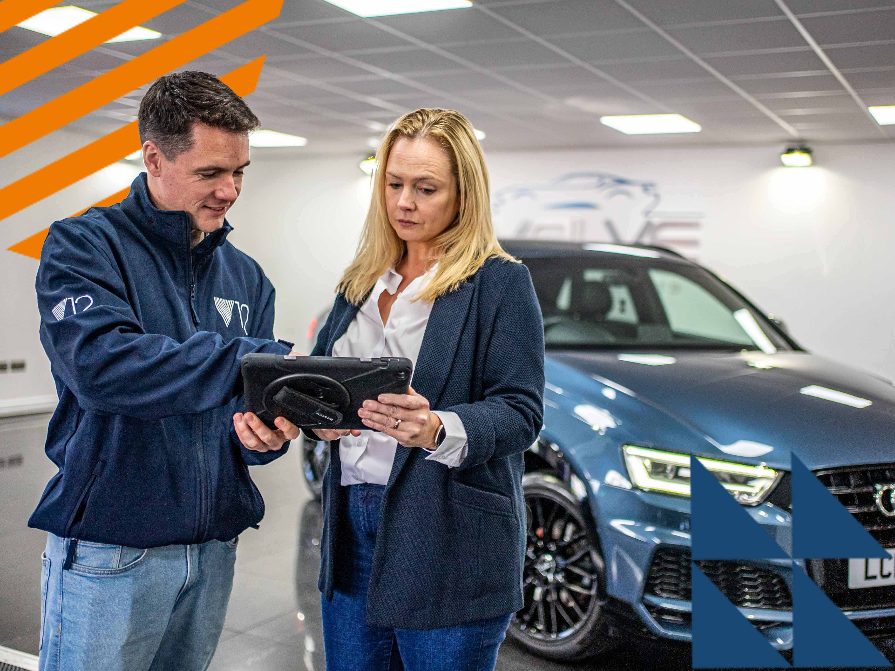 an account manager and a dealer looking at a digital tablet