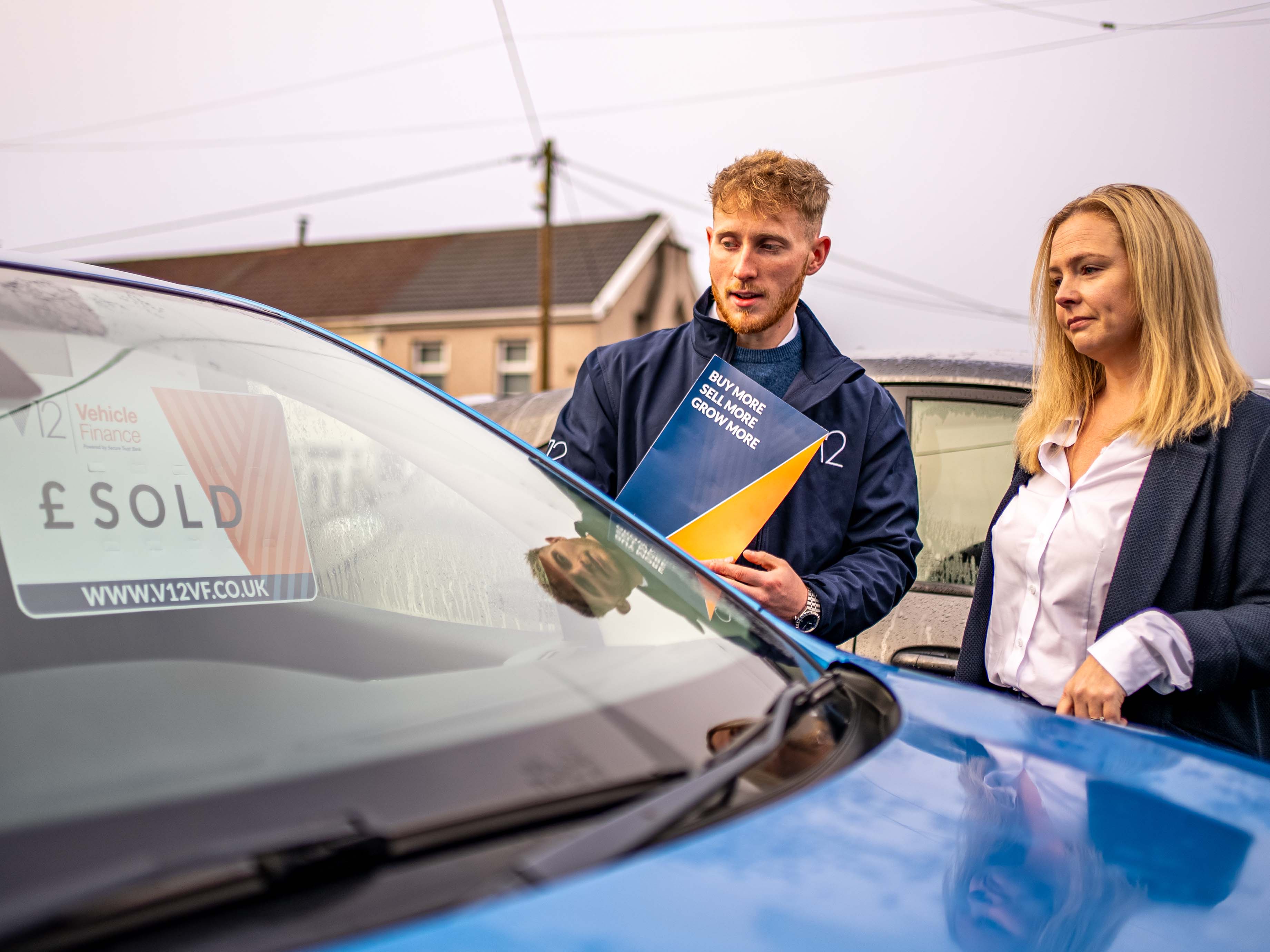 a dealer and an account manager looking at a vehicle